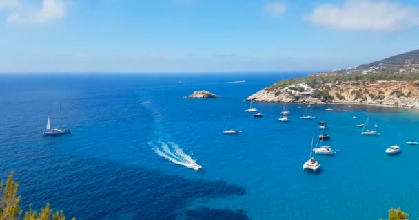 Famosa, hermosa playa a la luz del día con el mar tranquilo, en verano muy popular, costa de arena tienen una fantástica vista de la isla de ibiza. — Vídeo de stock