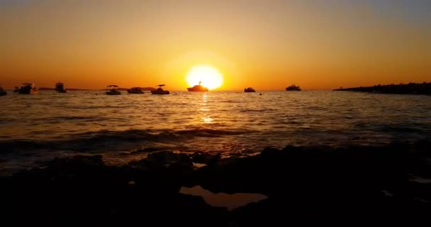 Tropická karibská pláž moře se zlatým pískem při západu slunce, barevná obloha s pomalým pohybem moře, dovolená s lodí na obzoru, — Stock video