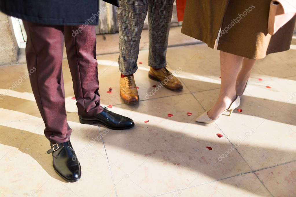 male and female legs standing on tiled floor during retro style party