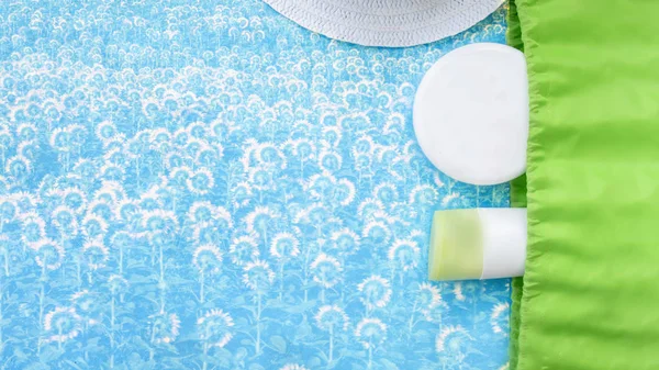 Beach bag with beach accessories on a texture blue background top view. Beach bag, sunscreen, cream. — Stock Photo, Image