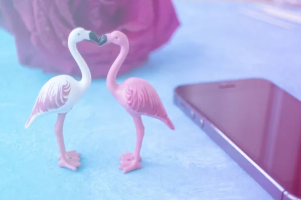 Dwa flamingi, telefon komórkowy i róża. Randki online, serwis randkowy — Zdjęcie stockowe