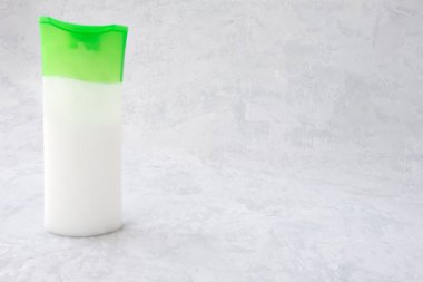 yeşil kapaklı beyaz şişe ve beyaz krem ve imza veya reklam güneş kremi