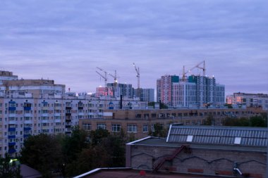 Günbatımında kuş gözü olan bir inşaat alanı. Drone 'la video çekimi. Kule vinci, kazıcı ve kum.