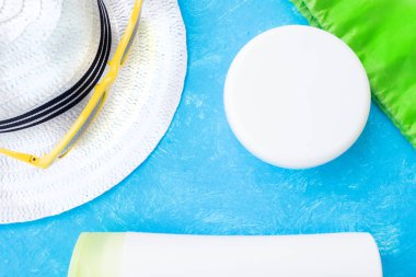 Creative layout with copy space, sunglasses and sunscreen or suntan lotion. Minimal summer vacation concept. Flat lay.