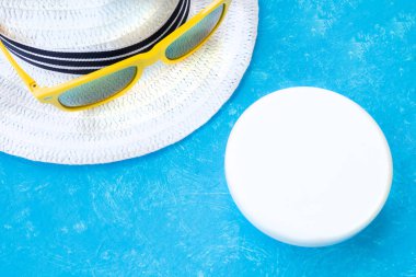 Creative layout with copy space, sunglasses and sunscreen or suntan lotion. Minimal summer vacation concept. Flat lay.