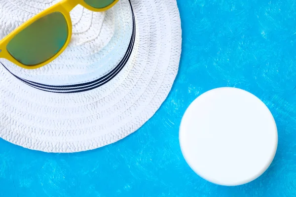 Creative layout with copy space, sunglasses and sunscreen or suntan lotion. Minimal summer vacation concept. Flat lay.