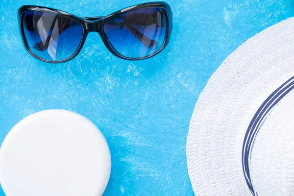 Güneş kremi ya da güneş kremi şişesi düz mavi arka planda, fotokopi alanı ile yatıyordu..