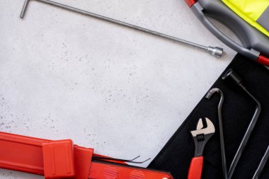 Araba acil durum kiti - uyarı üçgeni tehlike işareti, ilk yardım çantası ve yansıtıcı yelek, kriko cihazının metal kanca parçası.