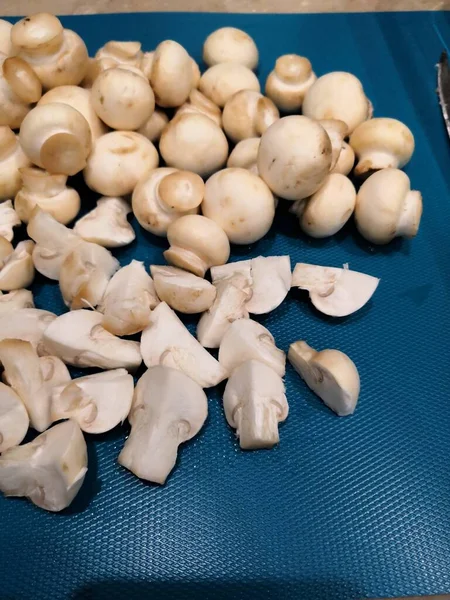 Μανιτάρια, κομμένα σε φέτες μανιτάρια, φέτες ωμά τρόφιμα σε μπλε — Φωτογραφία Αρχείου