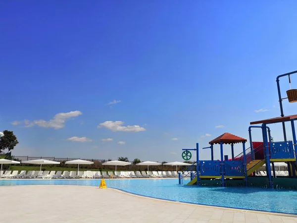 BURGAS AQUA PARK, BULGARY - 07.2019. Childrens slides in a park of different colors with a descent into the pool with clear clear water. water Park empty, childrens slides for descent