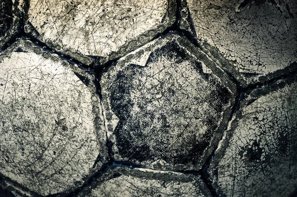 Used worn vintage soccer ball, close-up background with cracked grunge texture