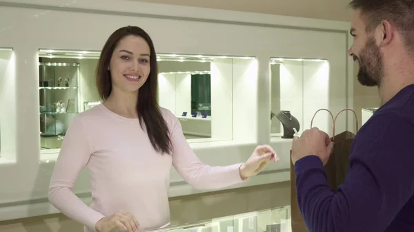 Female seller gives customer his purchase at the jewelry shop — Stock Photo, Image