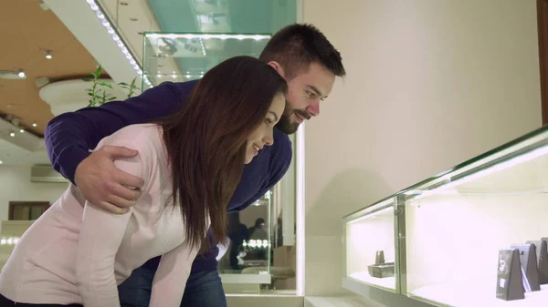 Пара смотрит на торговый дисплей с ювелирными изделиями в магазине — стоковое фото