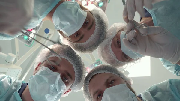 Equipe cirúrgica se dobra sobre o paciente — Fotografia de Stock