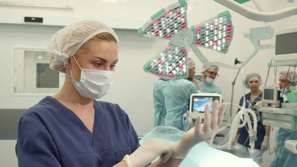 Nurse puts on gloves on her hands — Stock Photo, Image