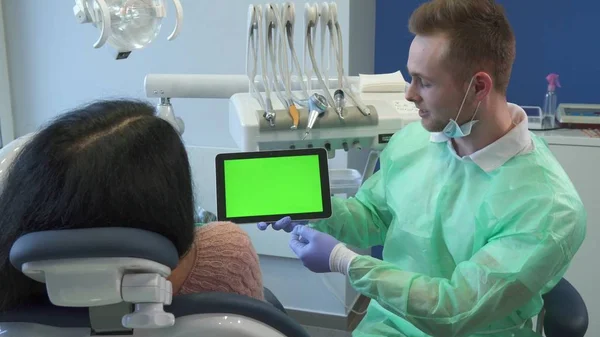 Dentysta wskazuje ręką na ekranie tabletu — Zdjęcie stockowe