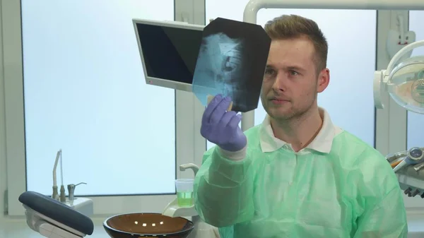 Стоматолог піднімає рентген на світло — стокове фото