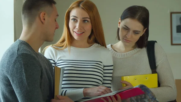 Female student shows her exercise book to her male classmate — Stock Photo, Image