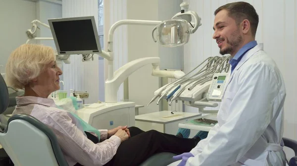 Dentysta pozdrawia kobieta klienta w jego biurze — Zdjęcie stockowe