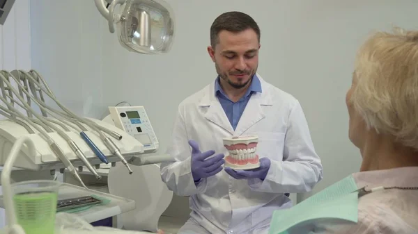 Dentysta narodowemu coś na układ zębów do jego kobieta klienta — Zdjęcie stockowe