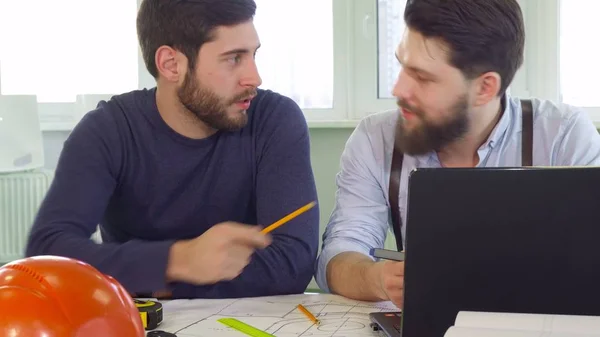 Arquiteto aponta seu lápis na tela do laptop — Fotografia de Stock