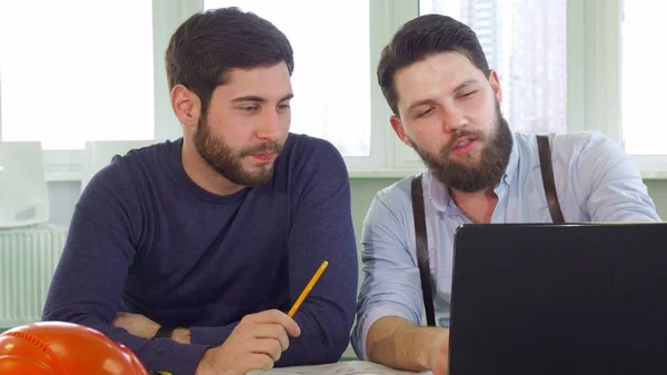 Zwei Architekten schauen auf Laptop-Bildschirm — Stockfoto