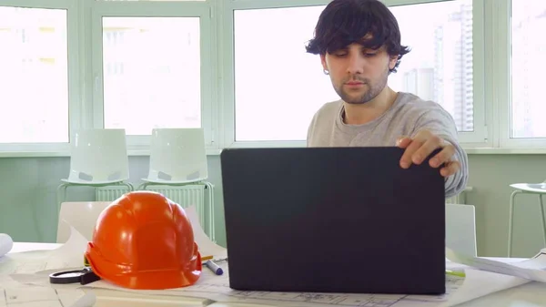 Архітектор закриває ноутбук в офісі — стокове фото
