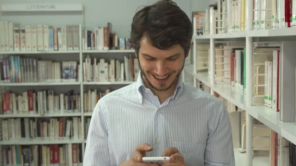 Man looks for a book at the library — Stock Photo, Image