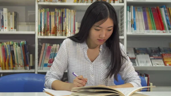 Female student studies at the library — Stock Photo, Image