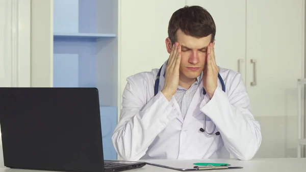 Мужчина-врач устает в офисе — стоковое фото