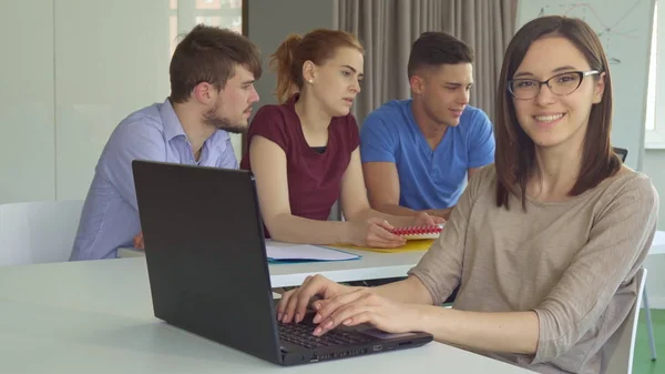 Menina mostra polegar na mesa com laptop — Fotografia de Stock