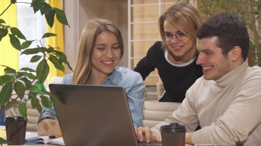Gençlerin bazı proje üstünde laptop tartışmak.