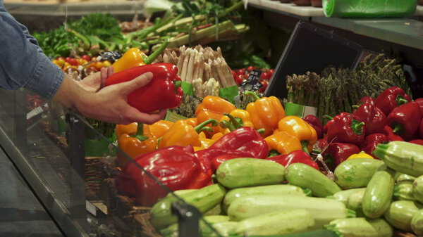 Man chooses between red and yellow bell peppers