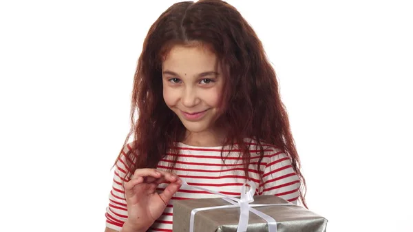 Una chica astuta desempaca su regalo de Año Nuevo —  Fotos de Stock