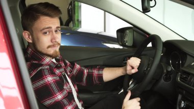 Genç adam yeni bir araba Bayilik salon iç incelenmesi