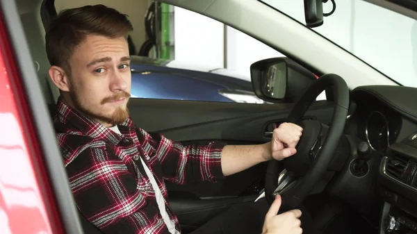 Genç adam yeni bir araba Bayilik salon iç incelenmesi