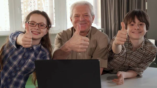 Homem sênior e seus netos mostrando seus polegares — Fotografia de Stock