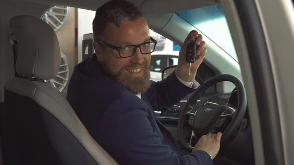 Male customer shows key inside the car