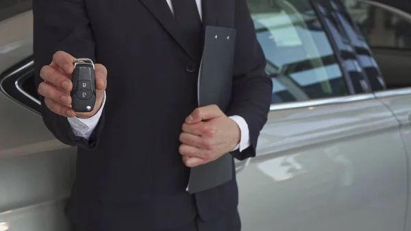 Gerente de vendas mostra chave perto do carro — Fotografia de Stock