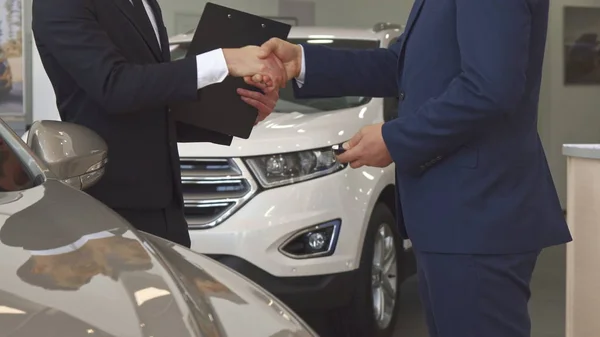 Sales manager sells car to the customer at the dealership