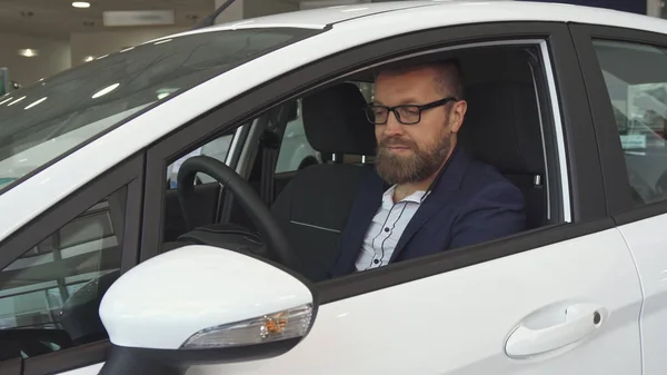 El cliente masculino examina el interior del coche en el concesionario — Foto de Stock