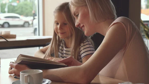 Kellner gibt dem kleinen Mädchen im Café etwas zu trinken — Stockfoto