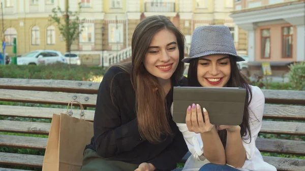 Amigos femininos assistem algo no tablet ao ar livre — Fotografia de Stock