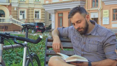 Bisikletçi tezgah üzerinde kitabın sayfa döner