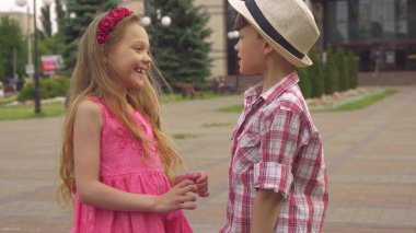 Küçük erkek ve kız açık havada konuşmak