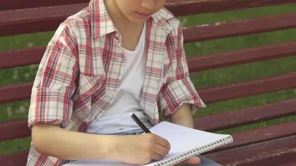 Little boy draws in his notebook on the bench — Stock Photo, Image
