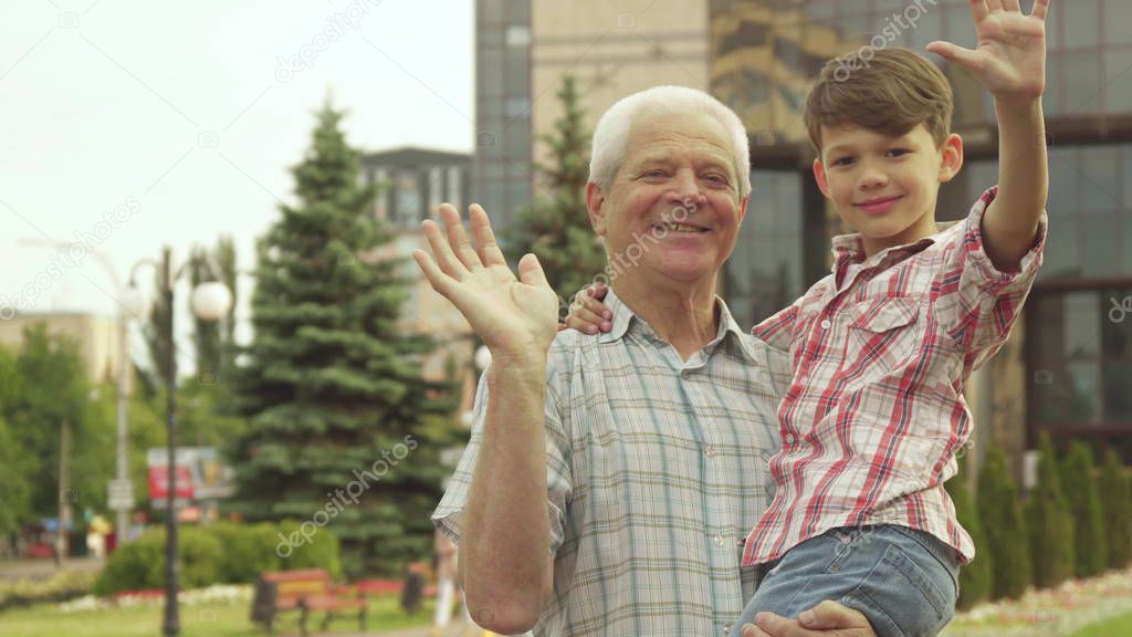 Senior man holds his grandson in his arms