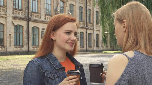 Две девушки разговаривают и пьют кофе — стоковое фото