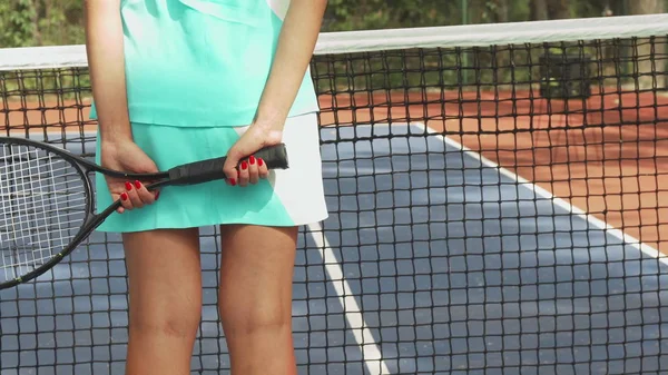 Girl standing with a racket turned back