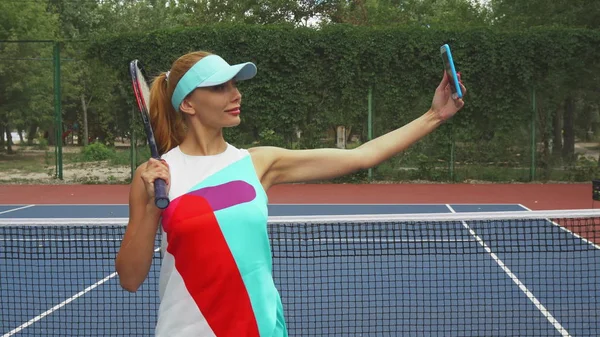 Menina de tênis tirando selfies em um tribunal — Fotografia de Stock